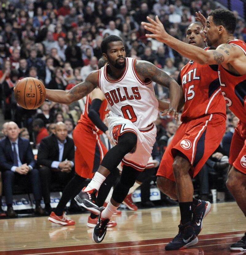 Chicago Bulls' Aaron Brooks (0) passes around Atlanta Hawks' Al Horford (15) and Thabo Sefolosha (25) during the second half of an NBA basketball game in Chicago on January 17. Atlanta won 107-99. Paul Beaty/AP