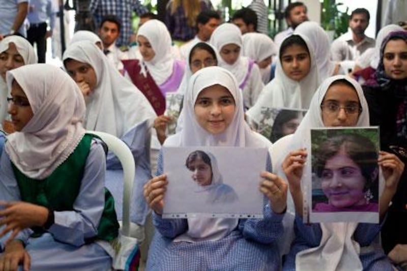 Schoolchildren at the Pakistan embassy in Abu Dhabi hold photographs of Malala Yousufzai, the 14-year-old rights activist shot by the Taliban. The ambassador to the UAE says her medical flight to the UK is due to land this afternoon.