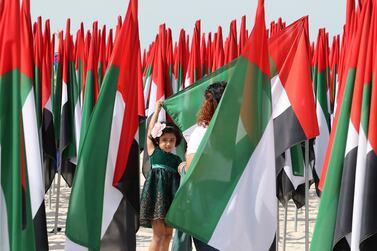 Anju Jacob taking the photo of her daughter Evelyn Dcruz (5years old) at the flag garden near the Kite beach on the UAE’s 50th National Day celebration in Dubai on 2nd December, 2021. Pawan Singh/The National.