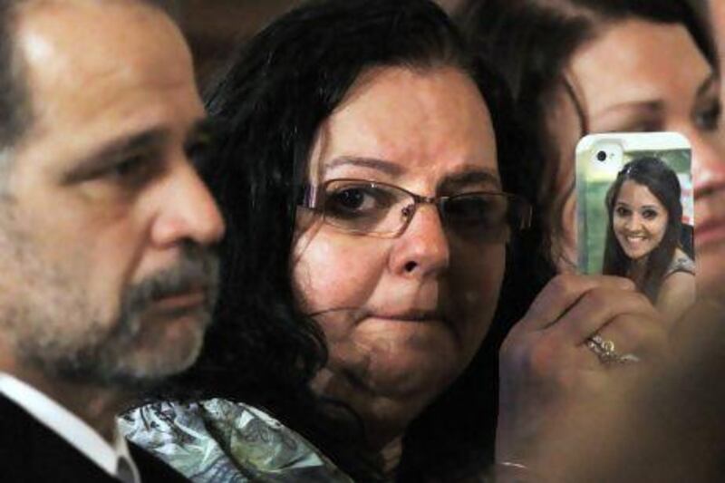 Donna Soto, mother of slain Sandy Hook Elementary School teacher Victoria Soto, holds a cell phone with her daughter's picture on it while attending a ceremony in the East Room of the White House on Friday. Jacquelyn Martin / AP Photo