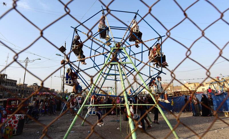 Children play on swings during Eid Al Fitr celebrations in Al Sadr city in Baghdad, Iraq. EPA