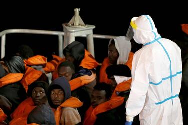 An Armed Forces of Malta soldier inspects newly arrived migrants in Valletta's Grand Harbour on Sunday. Reuters