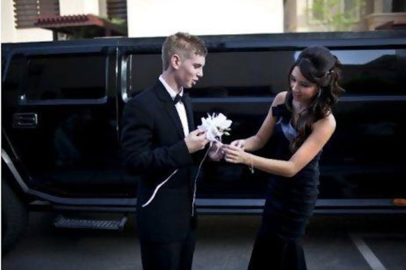 A stretch limo waits as Jessie Lyle helps her prom date Nic Kerkmeester with the corsage before heading out for their prom at the Fairmont hotel.