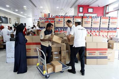 ABU DHABI, UNITED ARAB EMIRATES, August 19 – 2018 : Members of the Universal Rescue Team packing essential items such as slippers, clothes , food , medicines , blankets, baby items and other stuff in the aid boxes for the Kerala flood victims at the Universal Hospital in Abu Dhabi. ( Pawan Singh / The National )  For News. Story by John Dennehy