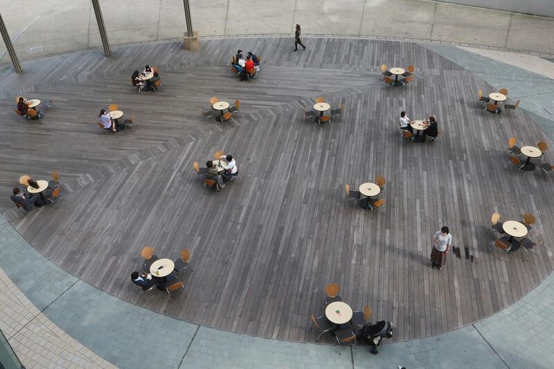 People keep a social distancing during a lunch time in Tokyo. AP Photo