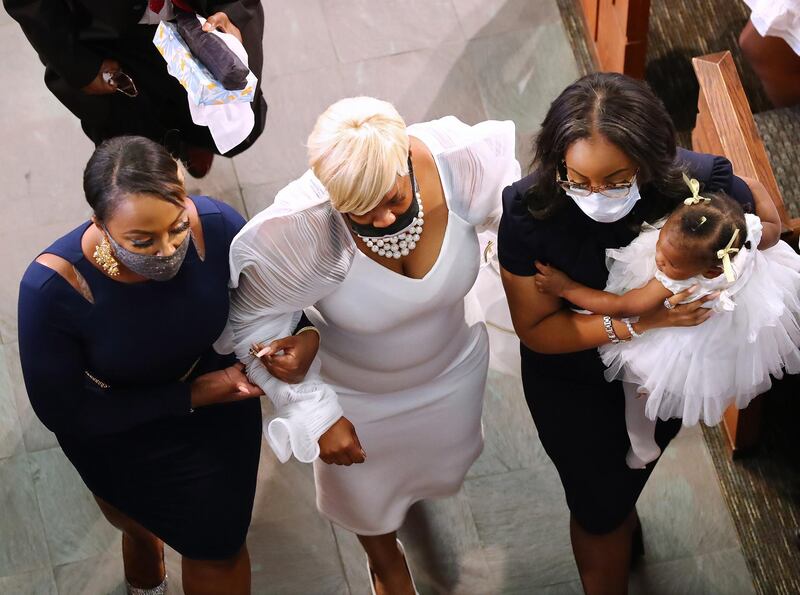 Tomika Miller, the widow of Rayshard Brooks, is led out at the end of his funeral. EPA