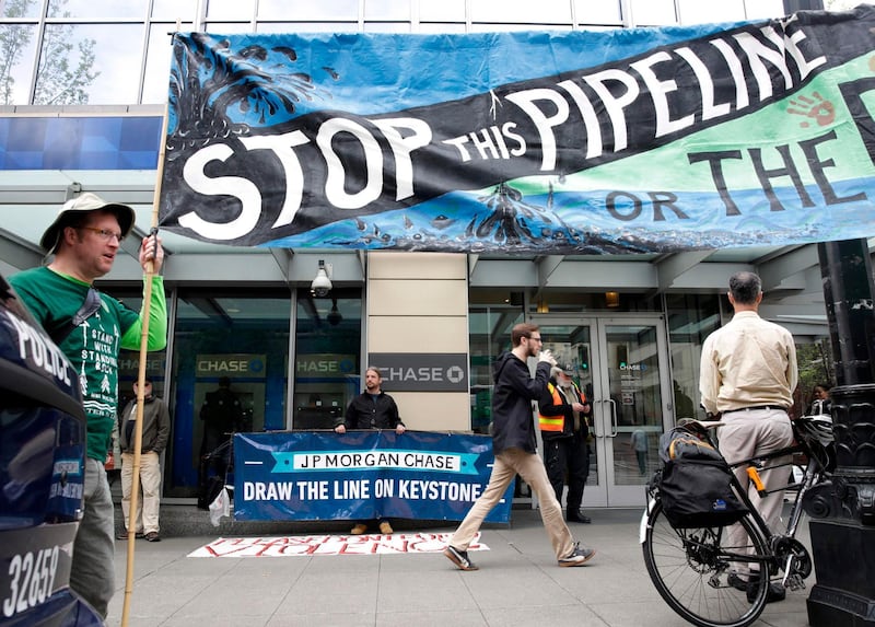 (FILES) In this file photo Indigenous leaders and climate activists disrupt business at a Chase Bank branch in Seattle  on May 8, 2017.  President-elect Joe Biden plans to scrap the permit for the controversial Keystone XL oil pipeline between Canada and the US, two Canadian broadcasters said on January 17, 2021. CBC and CTV cited sources and notes from Biden's transition team that indicate he will rescind the permit via executive order following his inauguration on January 20, 2021.
 / AFP / Jason Redmond
