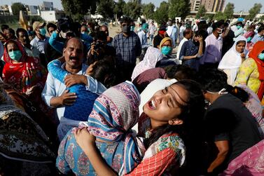 Relatives comfort each other as they mourn the death of Simon Eric, who was killed in a plane crash, during his burial at the Christian's Gora Cemetery in Karachi, Pakistan May 25, 2020. Reuters