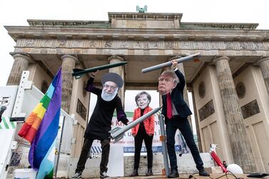 Anti-war activists hold mock nuclear missiles and wear masks of Ayatollah Ali Khamenei, Angela Merkel and Donald Trump in Berlin earlier in the week. EPA