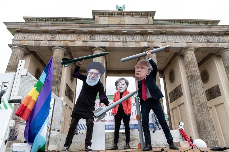 epa08118922 Anti-war activists hold mock nuclear missiles and wear masks of (L-R) Iranian Supreme Leader Ayatollah Ali Khamenei, German Chancellor Angela Merkel and US President Donald J. Trump as they perform in front of the Brandenburg Gate in Berlin, Germany, 11 January 2020. The activists from several peace organizations including IPPNW Germany, pax christi Germany, DVG-VK and more, call for ending the tensions between Iran and the United States following the killing of Iranian Revolutionary Guards Corps (IRGC) Lieutenant general and commander of the Quds Force Qasem Soleimani.  EPA/OMER MESSINGER