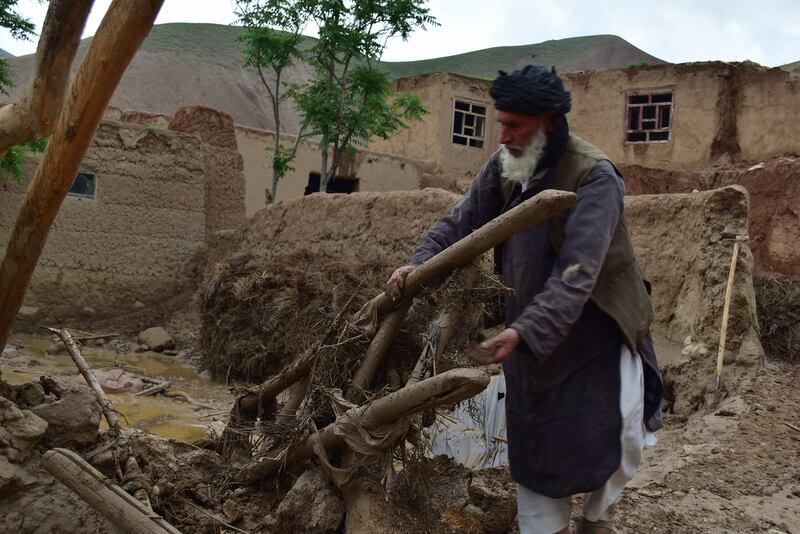 A man retrieves his belongings from his damaged home after heavy flooding in Baghlan province. AP 