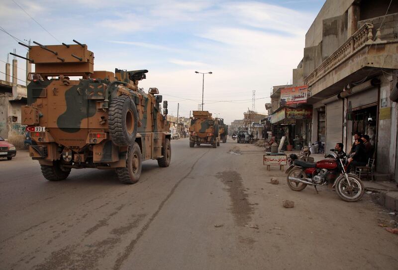 Turkish military vehicles drive in a convoy headed for the south of Idlib province as they pass by the town of Atareb in the western countryside of Aleppo.   AFP