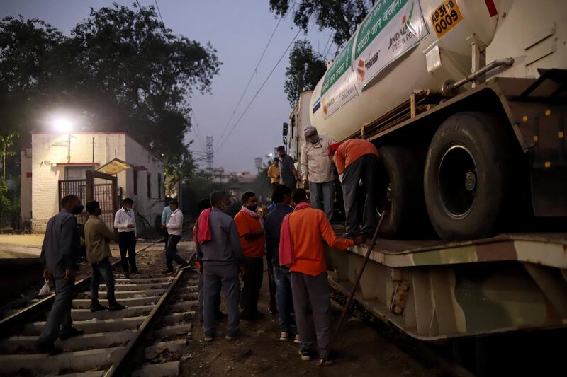 Workers unload a medical oxygen tanker from the 'Oxygen Express' train at Delhi Cantonment railway station. Bloomberg