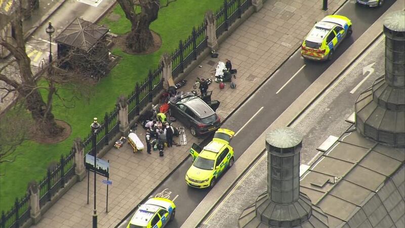 Police officers gather around a car adjacent to houses of parliament in London on March 23, 2017 after the House of Commons sitting was suspended as witnesses reported sounds like gunfire outside. ITN via AP