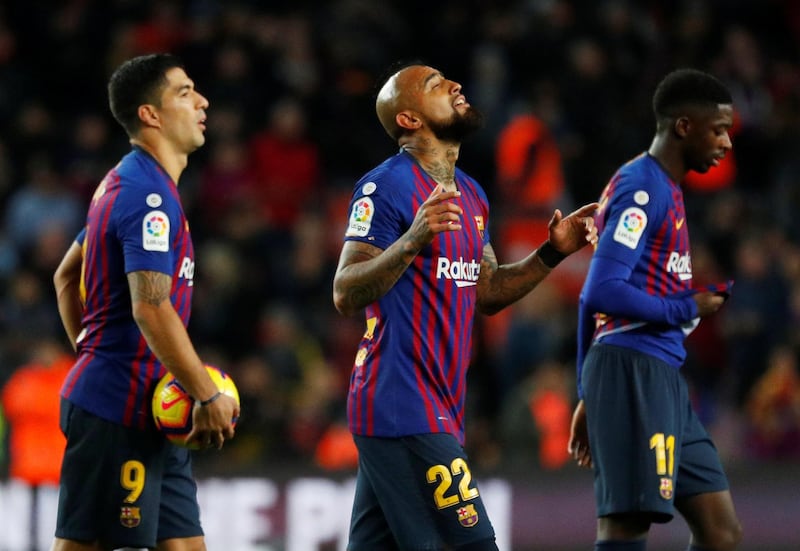 Barcelona's Luis Suarez celebrates with the match ball alongside Arturo Vidal and Ousmane Dembele at the end of the match. Reuters