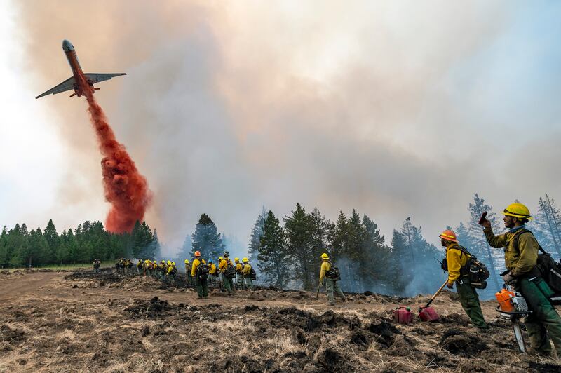 Firefighters watch and record videos with their phones as a plane drops fire retardant on Harlow Ridge above the Lick Creek Fire, south-west of Asotin, Washington.  The fire, which started last Wednesday, has now burned over 50,000 acres of land between Asotin County and Garfield County in south-east Washington state.