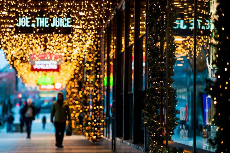 People walk past shops under Christmas lights in Stockholm. AFP