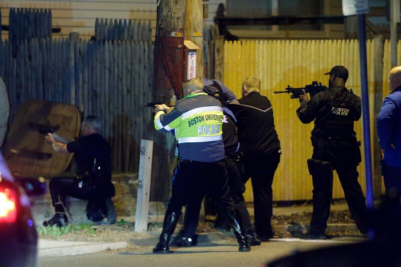 Police officers aim their weapons Friday, April 19, 2013, in Watertown, Mass. A tense night of police activity that left a university officer dead on campus just days after the Boston Marathon bombings and amid a hunt for two suspects caused officers to converge on a neighborhood outside Boston, where residents heard gunfire and explosions.(AP Photo/Matt Rourke) *** Local Caption ***  APTOPIX Police Converge Mass.JPEG-02298.jpg