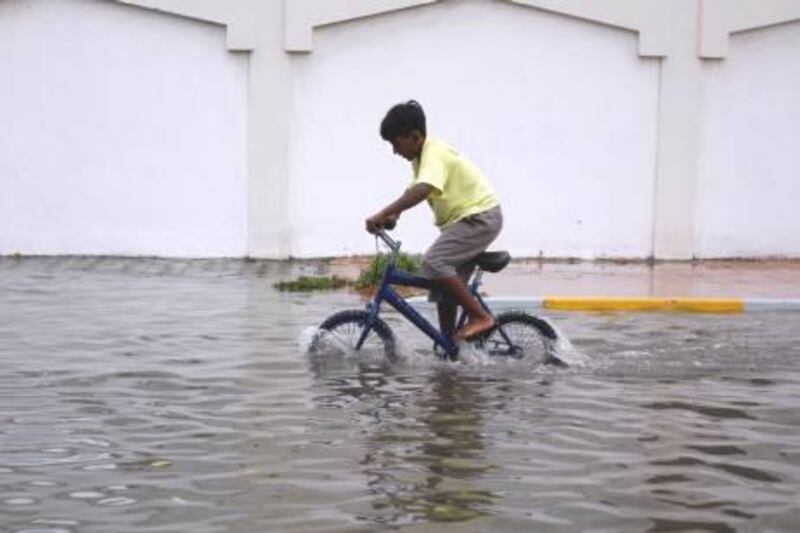 March 2, 2010/ Abu Dhabi / a boy , takes advantage of the flooding near his house riding his bike in Abu Dhabi March 2, 2010.  Heavy overnight rains fell in Abu Dhabi causing sporadic flooding in low line areas. (Sammy Dallal / The National)


