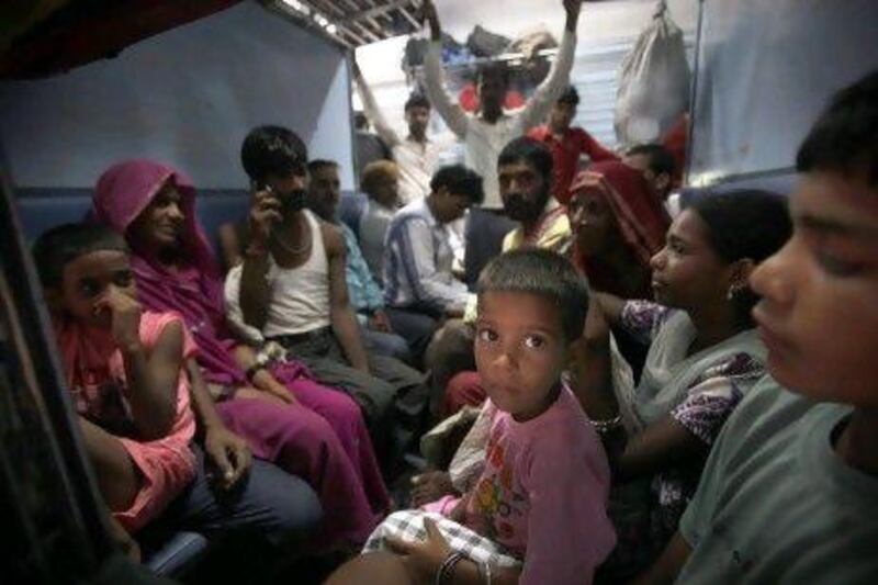 Passengers sit in a train waiting for power to be restored at a railway station in New Delhi. A major power outage yesterday plunged cities into darkness and stranded hundreds of thousands of commuters.