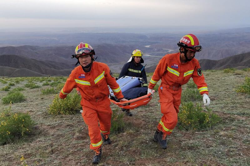 This photo taken on May 22, 2021 shows rescuers carrying equipment as they search for runners who were competing in a 100-kilometre cross-country mountain race when extreme weather hit the area, leaving at least 20 dead, near the city of Baiyin in China's northwestern Gansu province. China OUT
 / AFP / STR
