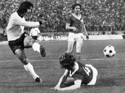 (FILES) In this file photo taken on June 22, 1974 West German forward Gerd Müller (L) kicks the ball past East German defender Konrad Weise (R) as forward Martin Hoffmann looks on during the World Cup first round match between East Germany and West Germany in Hamburg.   / AFP / STAFF
