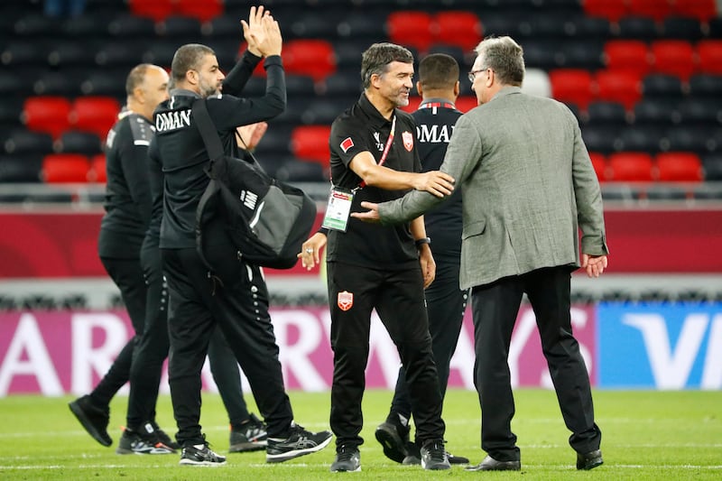 Bahrain's coach Helio Sousa, centre, and Oman's coach Branko Ivankovic, right, after the Group B match in the Qatari city of Ar Rayyan on December 6, 2021.