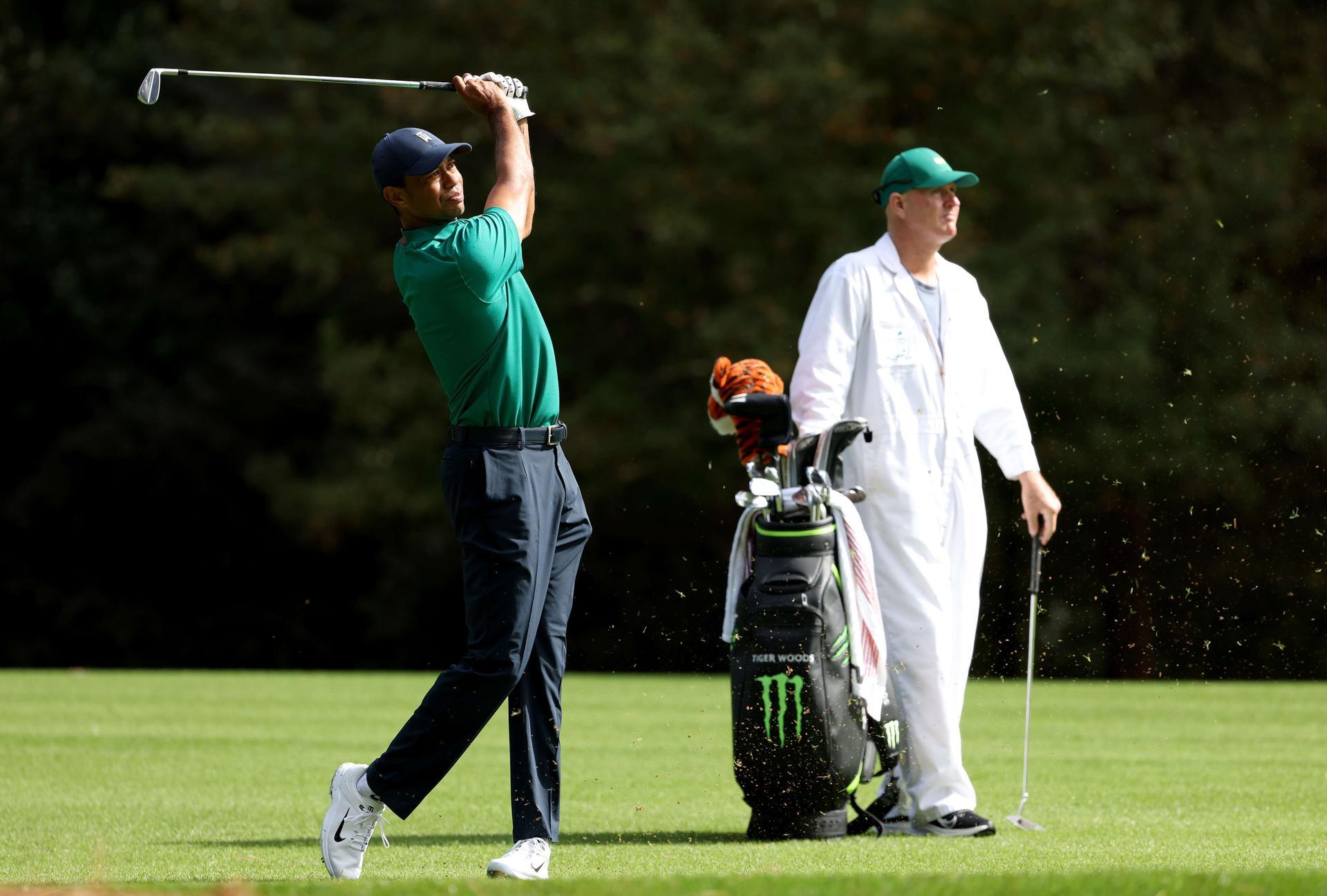 Tiger Woods plays a shot on the 11th hole as caddie Joe LaCava looks on during a practice round prior to the Masters. AFP