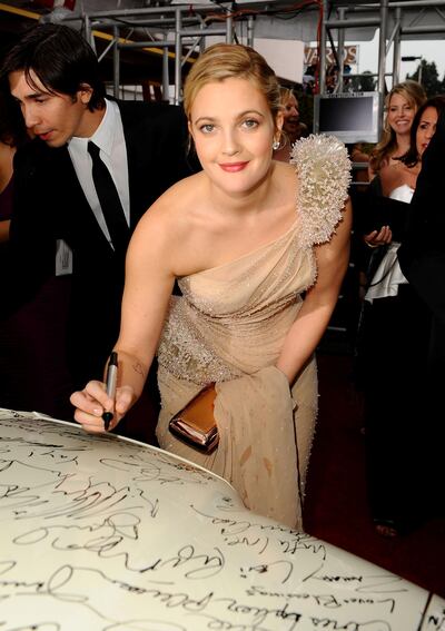 BEVERLY HILLS, CA - JANUARY 17: Actress Drew Barrymore signs the Chrysler 300 Eco Style car for Stars for a Cause during the 67th annual Golden Globe Awards held at The Beverly Hilton Hotel on January 17, 2010 in Beverly Hills, California. This Chrysler 300 is one of seven in existence.   Michael Caulfield/Getty Images/AFP