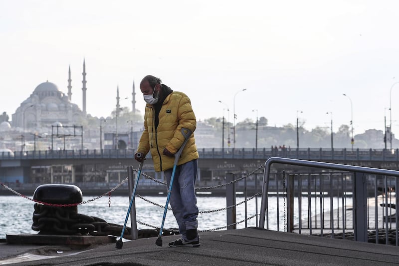 epa08394380 A man wearing a protective face mask walks on crutches in front of the Suleymaniye Mosque in Istanbul, Turkey, 30 April 2020, amid the ongoing coronavirus COVID-19 pandemic. Turkish President Recep Tayip Erdogan announced that there will be curfew in 31 big cities, including Istanbul (the country's most populous urban agglomeration), between 01-03 May due to the ongoing pandemic of the COVID-19 disease caused by the SARS-CoV-2 coronavirus. The government has also decreed the cancellation of public events and has temporarily shut down schools and suspended sporting events.  EPA/SEDAT SUNA
