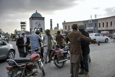 Afghan policemen search people at a checkpoint at the Chawk-e-Shahidan in Kandahar on December 13, 2020. - Dozens of Taliban fighters were killed in fierce overnight fighting between Afghan forces and militants who attacked multiple checkpoints in the insurgent bastion of Kandahar, officials said on December 13. (Photo by JAVED TANVEER / AFP)