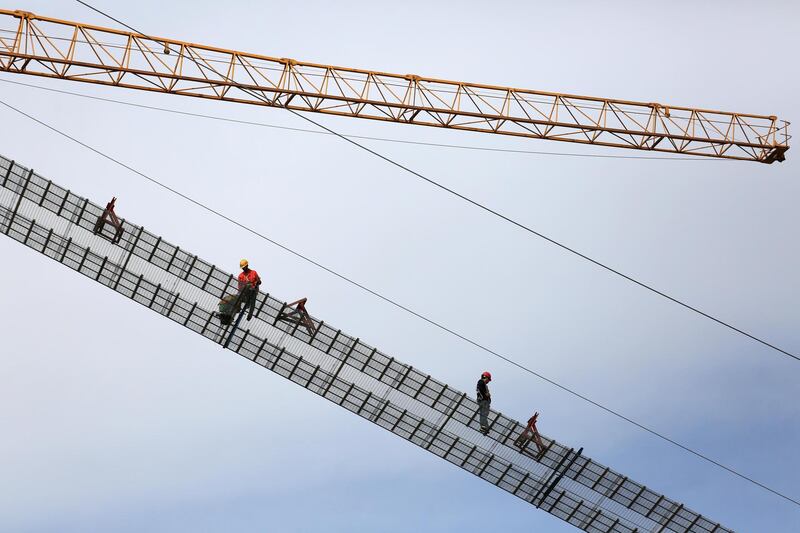 Workers are seen at the construction site of Panggong bridge over the Han river in Xiangyang, Hubei province, China.  Reuters