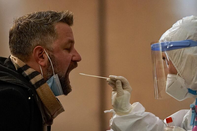 A medical staff takes a swab from a foreign reporter who was selected to cover the opening session of the Chinese People's Political Consultative Conference (CPPCC) and National Party Congress (NPC) at a quarantine hotel in Beijing, Thursday, March 4, 2021. Calls for a boycott of the 2022 Beijing Winter Olympics on human rights grounds are "doomed to failure," a Chinese government spokesperson said on Wednesday, as lawmakers and political advisers began converging on China's capital for the biggest annual gathering of the political calendar. (AP Photo/Andy Wong)