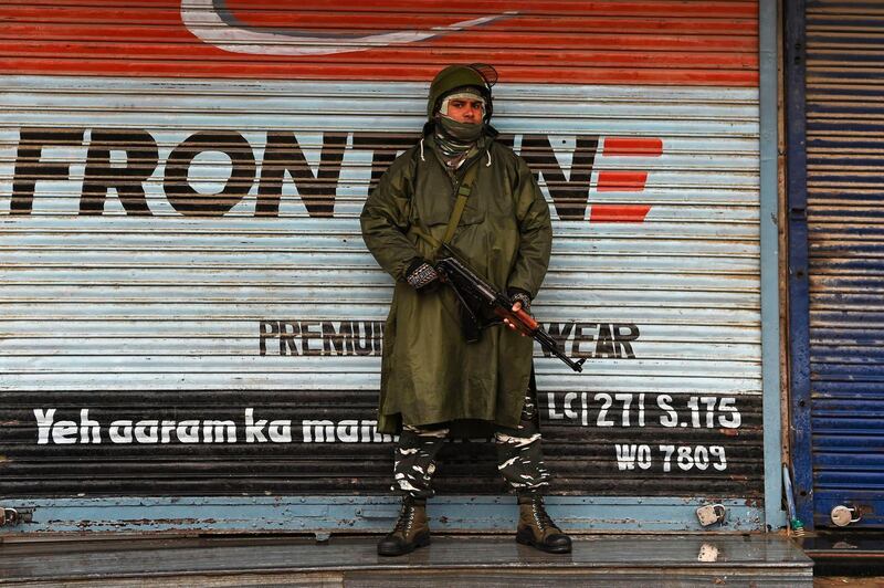 An Indian paramilitary trooper stands guard infront of closed shops during a lockdown in Srinagar on November 22, 2019. / AFP / Tauseef MUSTAFA

