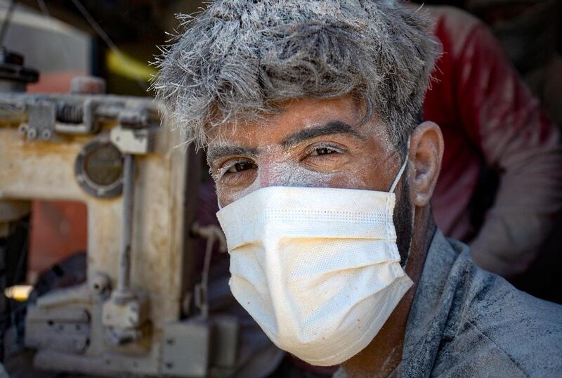 Dust and a mask complete the image of a rugged dockyard labourer at the Iraqi port of Umm Qasr near Basra. AFP