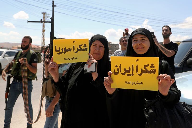 Hezbollah supporters with placards in Arabic that read "Thank you Iran," right, and "Thank you Syria." AP Photo
