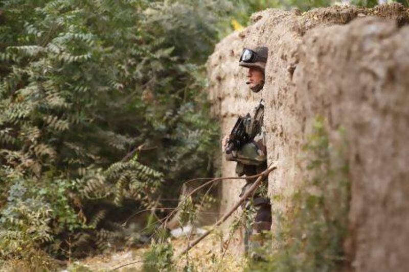 A French soldier secures an area during an ordinance clearing exercise at a destroyed Islamic militant camp in the recently liberated town of Diabaly.