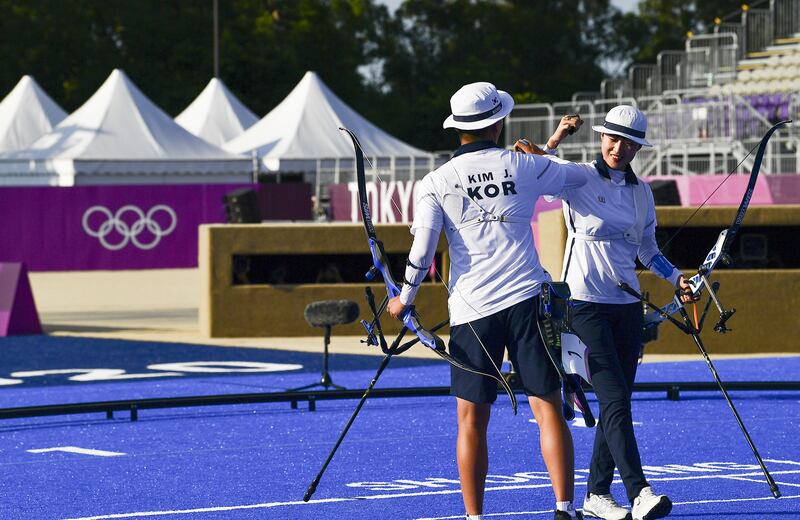Kim Je Deok and An San of South Korea celebrate gold in the archery mixed team event.