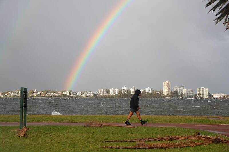 A person walks along the Swan river foreshore, which is partially closed due to storm flooding, in Perth, Western Australia.  EPA