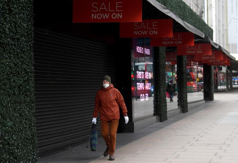 A masked man passes a closed shop on Oxford Street in London. EPA