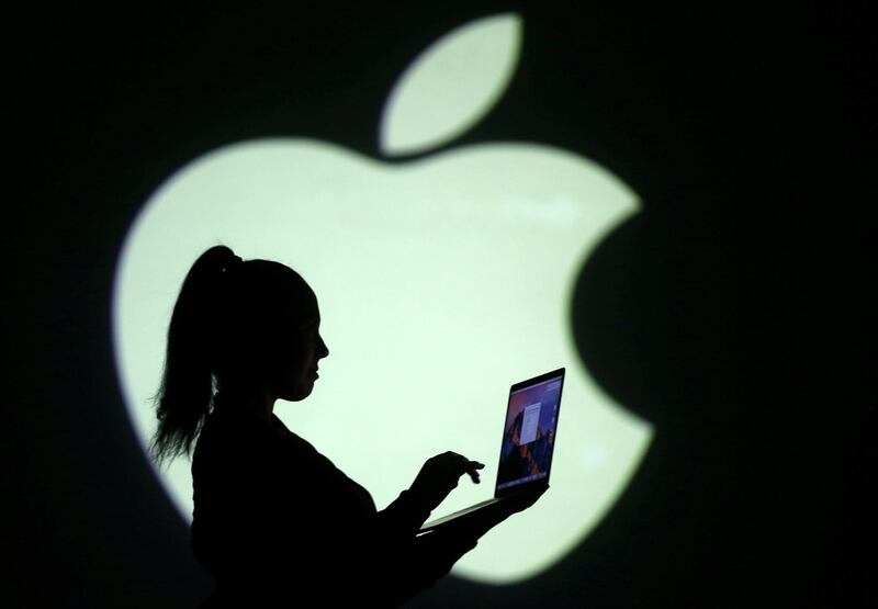 REFILE - CLARIFYING CAPTION Silhouette of laptop user is seen next to a screen projection of Apple logo in this picture illustration taken March 28, 2018.  REUTERS/Dado Ruvic/Illustration