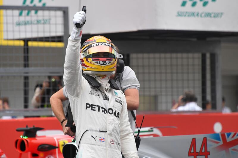 Mercedes' British driver Lewis Hamilton celebrates taking pole position in the qualifying session of the Formula One Japanese Grand Prix at Suzuka on October 7, 2017. / AFP PHOTO / Toshifumi KITAMURA