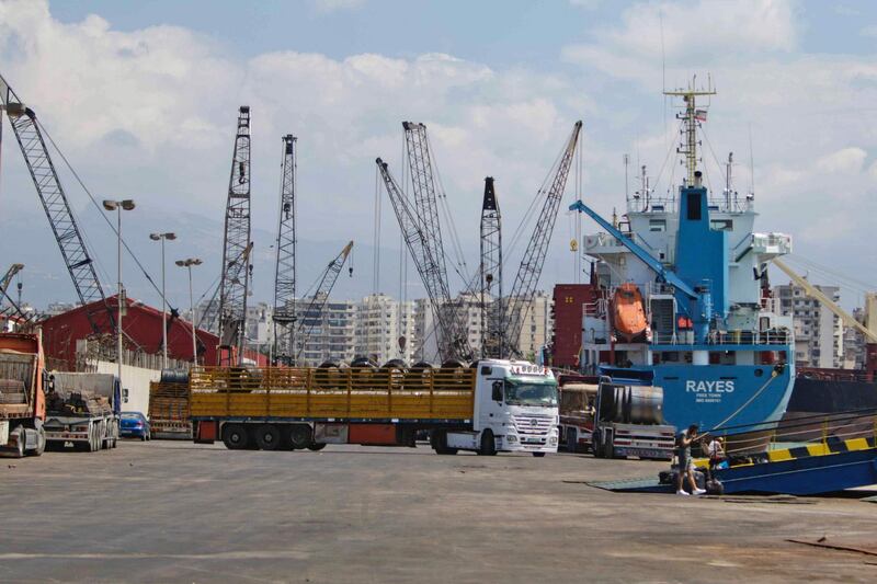 Mobile cranes and trucks at work at Tripoli port. AFP
