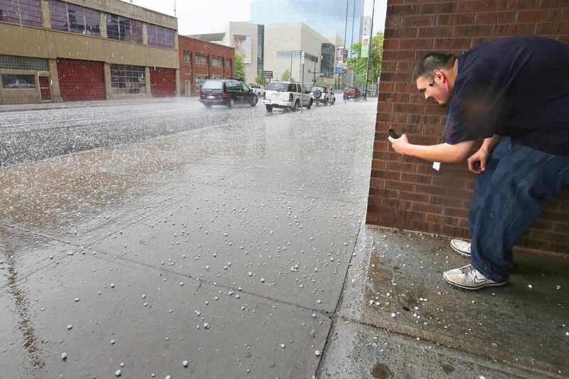 The costliest disaster for the insurance sector during the first six months was the thunderstorms and hail which hit the United States in mid-May, causing $3.2 billion in damage, of which $2.6bn was insured. Above, a resident takes a close up photo of hail as a storm cloud passes over downtown Denver. Brennan Linsley / AP Photo