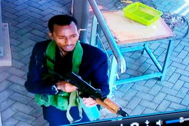 In this grab taken from security camera footage released to the local media, an armed attacker walks in the compound of a hotel, in Nairobi, Kenya, Tuesday, Jan. 15, 2019. Extremists launched an attack on a luxury hotel in Kenya's capital, sending people fleeing in panic as explosions and heavy gunfire reverberate through the neighborhood. A police officer says he saw bodies, "but there was no time to count the dead." Al-Shabab _ the Somalia-based extremist group _ is claiming responsibility. (Security Camera Footage via AP)