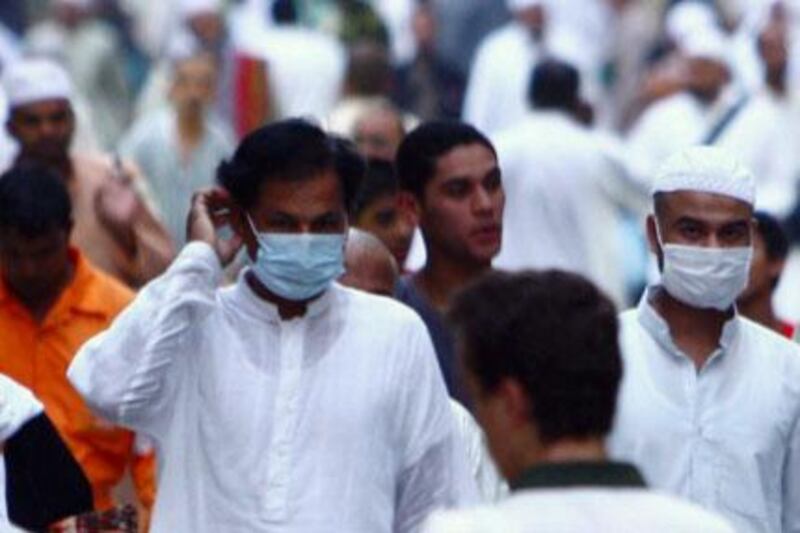 Muslims wearing masks walk outside the Grand Mosque after night prayer in Mecca.