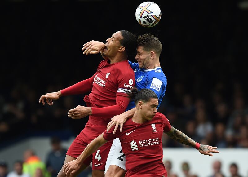 Everton's James Tarkowski leaps with Liverpool's Virgil van Dijk and Darwin Nunez. EPA