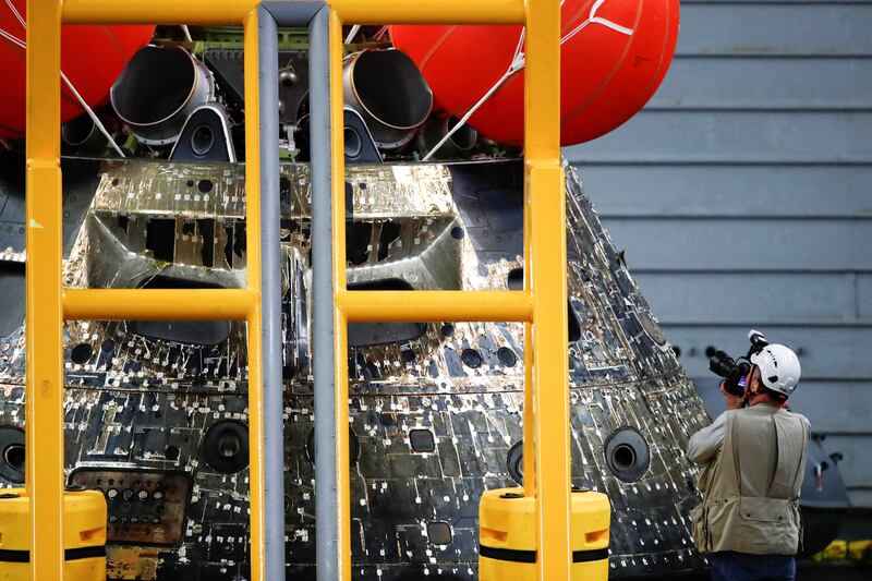 An Orion team member inspects the space capsule on the USS Portland. Reuters
