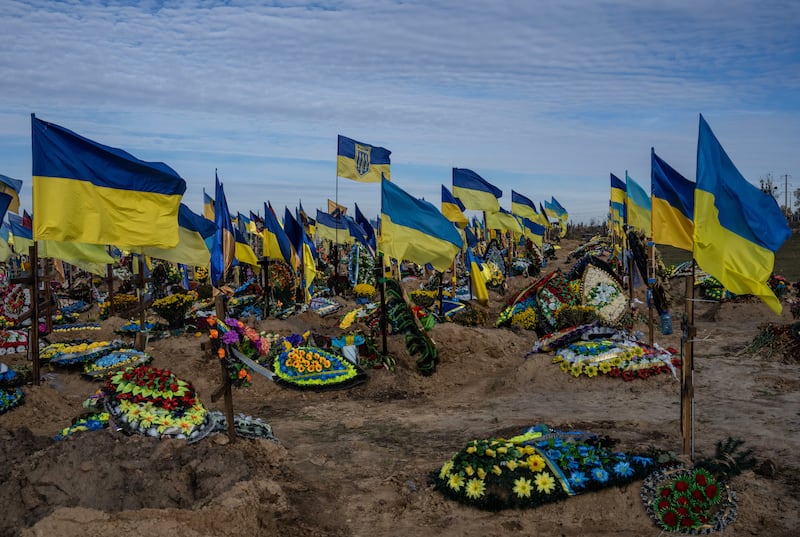 Ukrainian flags flutter around graves in a cemetery for soldiers killed in action in Kharkiv in October 2022. Getty Images