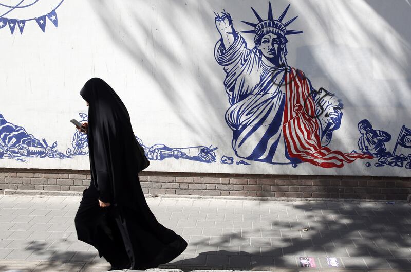 An Iranian woman walks past an anti-US mural near the former American embassy in Tehran. EPA